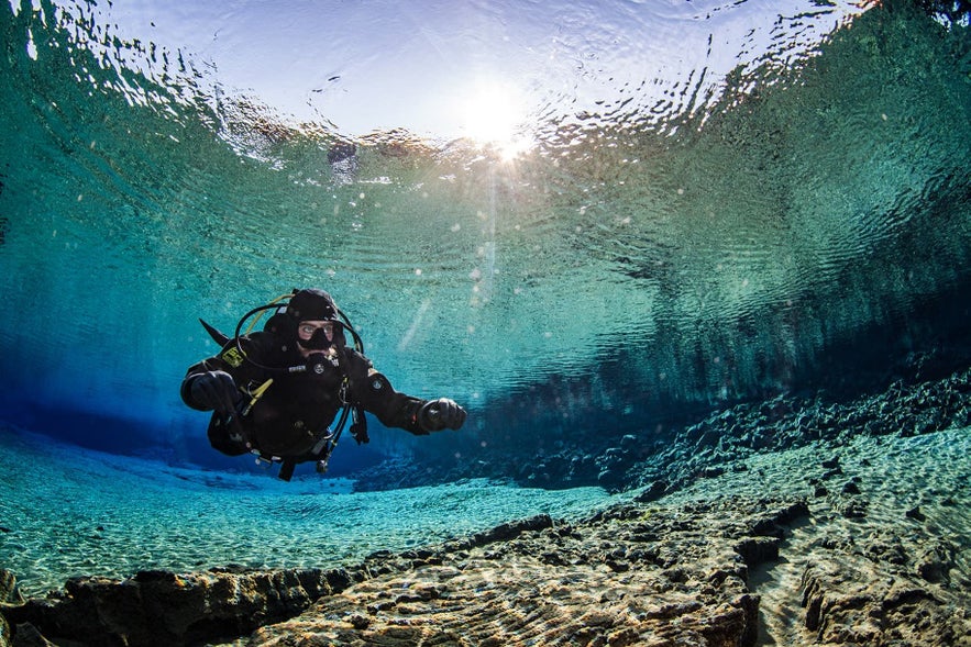 Scuba diver exploring the crystal-clear waters of Silfra Fissure in Thingvellir National Park, Iceland. Scuba diver exploring the crystal-clear waters of Silfra Fissure in Thingvellir National Park, Iceland.