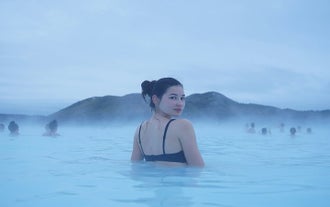 A guest enjoys a relaxing bath in the Blue Lagoon of Iceland.