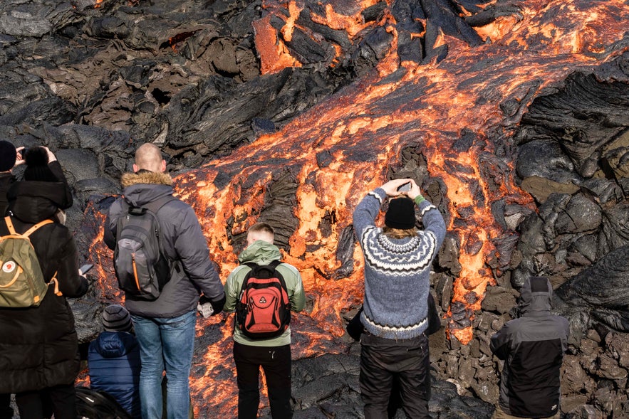 Vulkanische Spalteneruption am Berg Fagradalsfjall nahe der Ortschaft Grindavik auf der Halbinsel Reykjanes im Südwesten Islands. Die Lava fließt in das Tal Geldingadalur. Besucher können das Gebiet bereten. Die Sicherheit wird durch Rettungsteams, Wissenschaftler und Polizei gewährleistet, die das Gebiet bei Gefahr sperren.