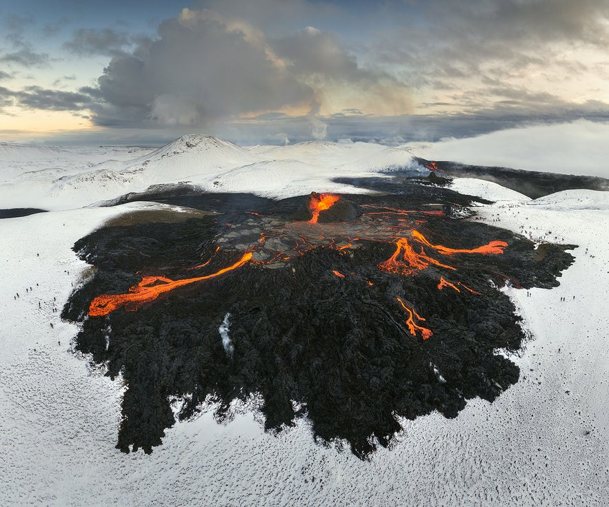 Smoke fills the area above the glowing lava field of the active Geldingadalur volcanic area.