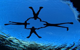 A group of adventurers forming a heart shape while snorkeling in Silfra.