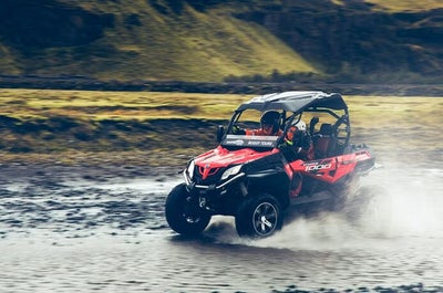 A buggy adventurer crossing a shallow river in Iceland.