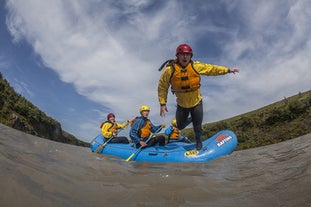 A man jumps into the Hvita river from a raft.