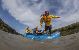 A man jumps into the Hvita river from a raft.