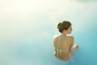 Une femme est assise dans les eaux du Blue Lagoon.