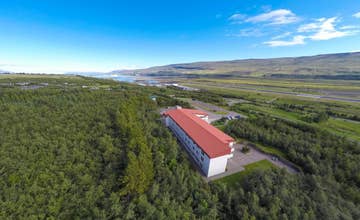 Vue aérienne de l’Hotel Kjarnalundur entouré par la campagne verdoyante du nord de l’Islande.
