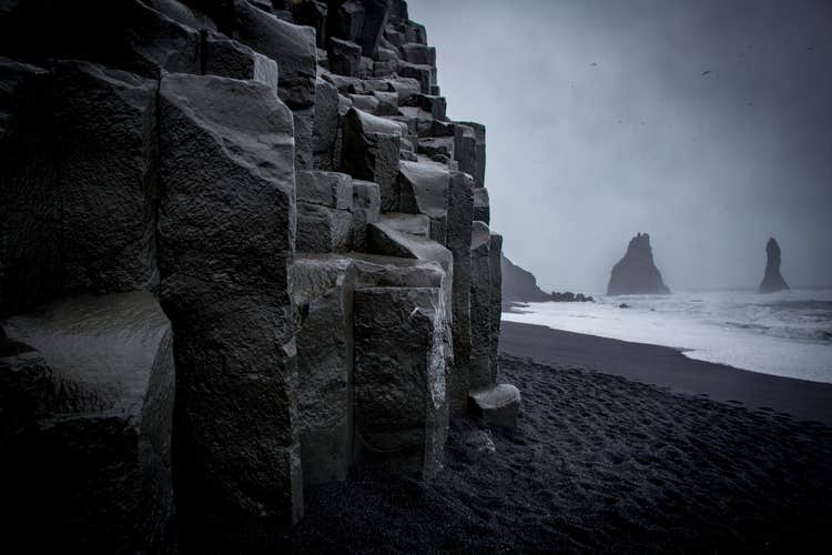 Close-up of dark basalt column formations at Reynisfjara Black Sand Beach in Iceland.