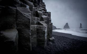 Close-up of dark basalt column formations at Reynisfjara Black Sand Beach in Iceland.
