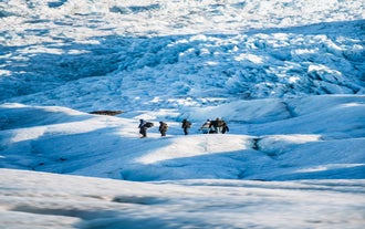 A group exploring the spectacular ice formations of the Falljokull glacier.