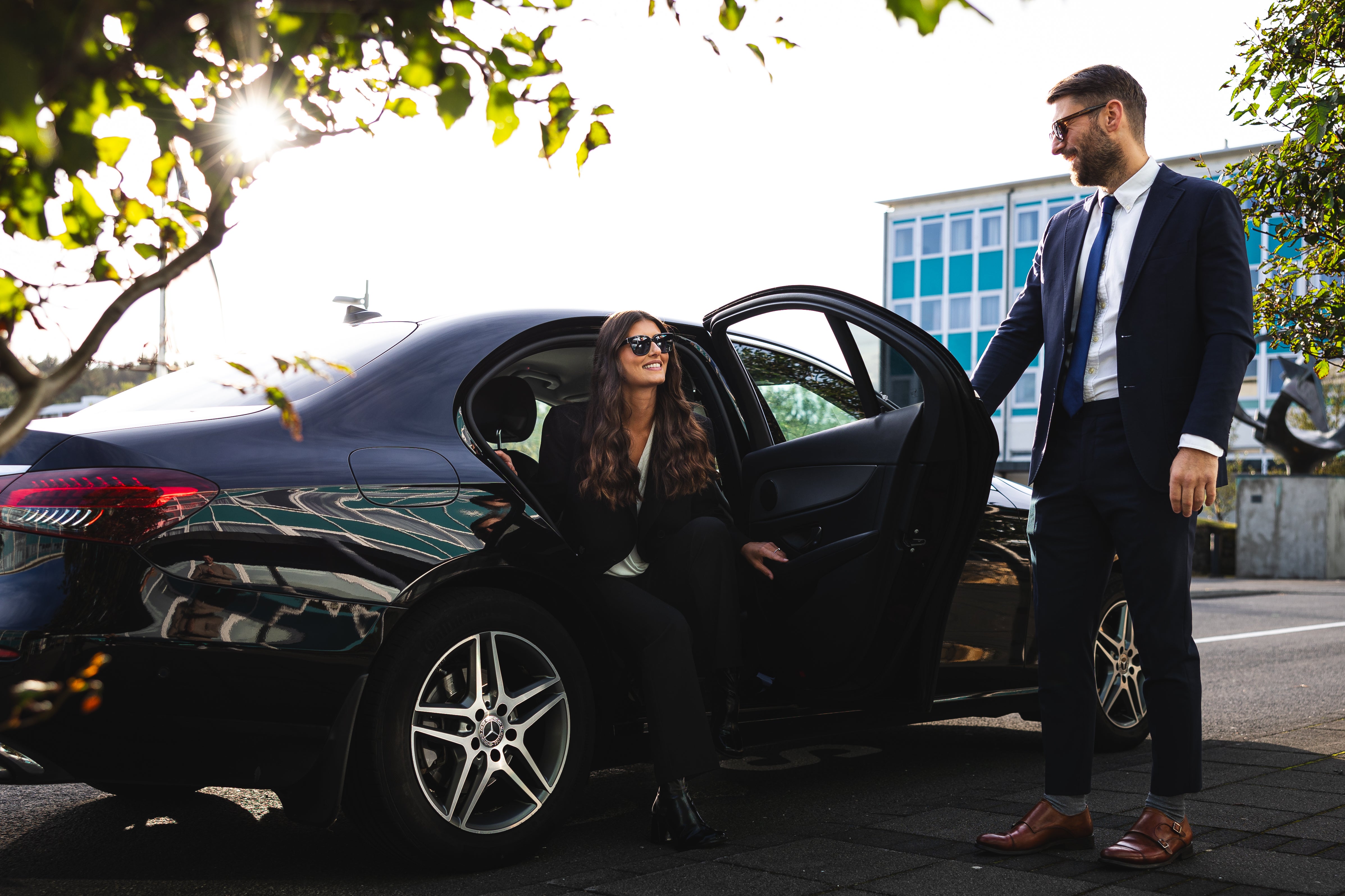 Woman stepping out of a luxury car with a chauffeur’s assistance in Reykjavik.