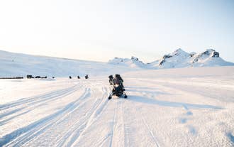 Las motos de nieve recorren el glaciar Langjokull de Islandia bajo la suave luz de un día claro de invierno.