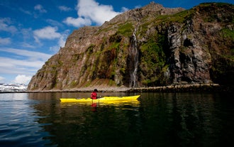 A person in a yellow kayak in the Westfjords.