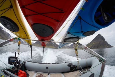 A boat with kayaks strapped to it sails to Hornstrandir.