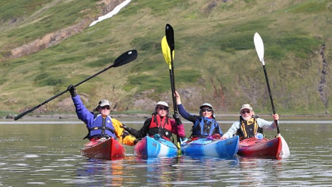 A group of kayakers celebrate their journey in Iceland.