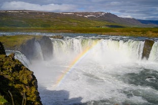 A colourful rainbow shows over Godafoss waterfall.