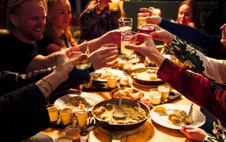 Travelers raise a toast over a table laden with local delicacies