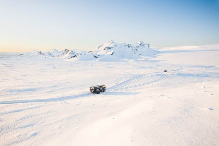 Tourist fährt mit einem Schneemobil auf einem isländischen Gletscher und genießt die malerische Winterlandschaft.