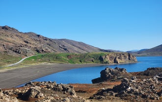A zoomed-out view of Lake Kleifarvatn with volcanic mountains near Harfnarfjordur in the distance.