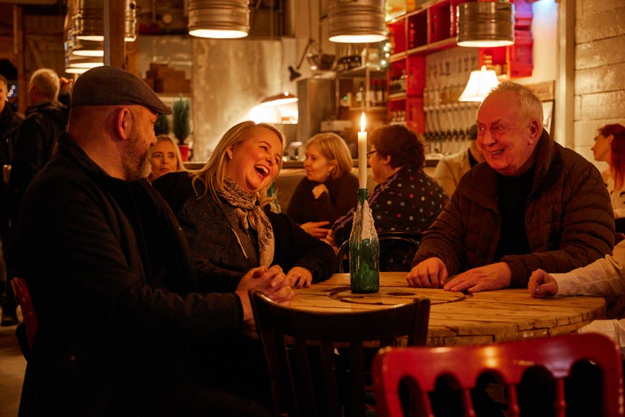 A group of people enjoying drinks at a table in a popular craft beer restaurant in Hafnarfjordur, Ægir 220. 