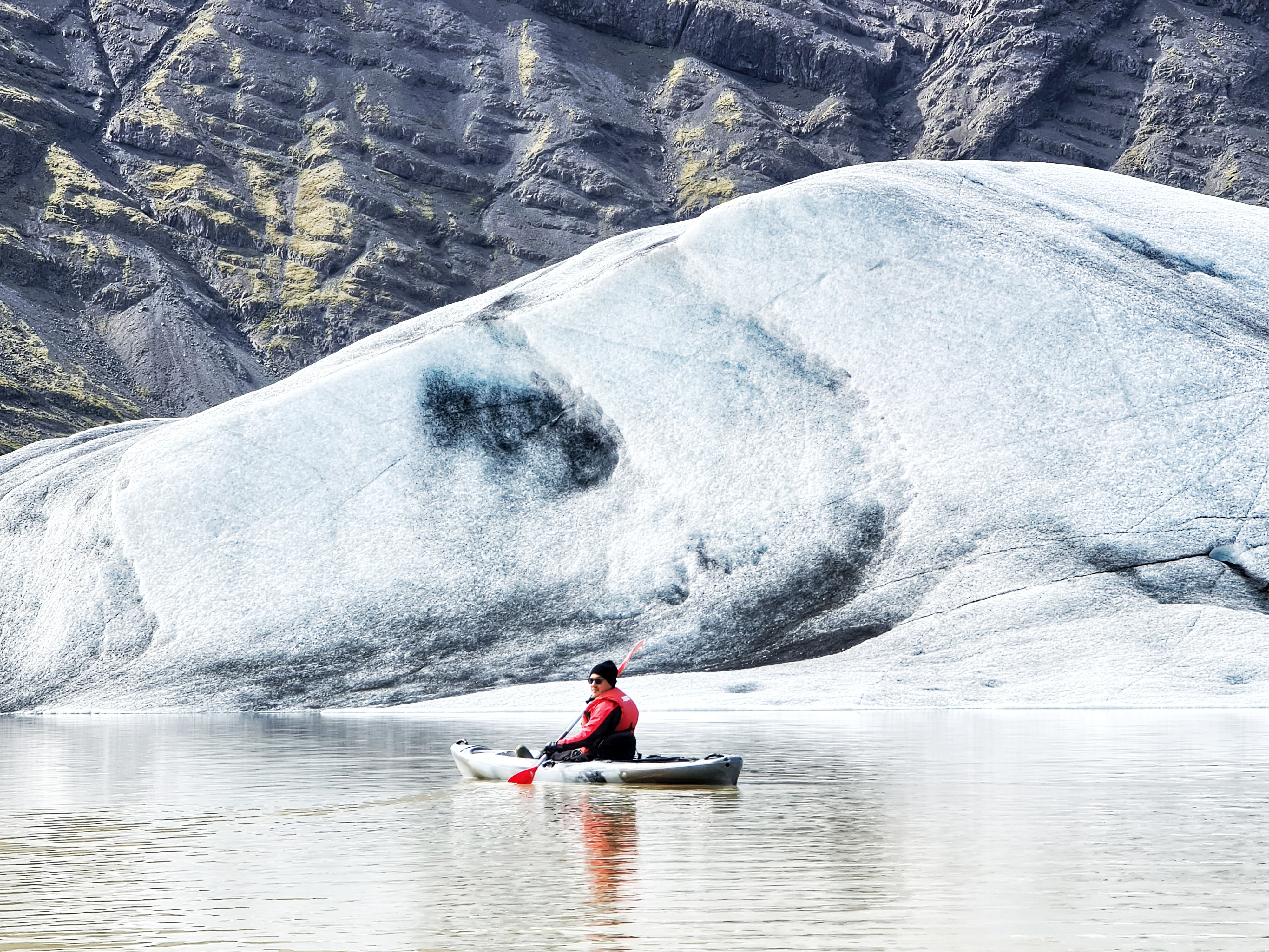 A kayaker travels through Heinaberg glacier lagoon.