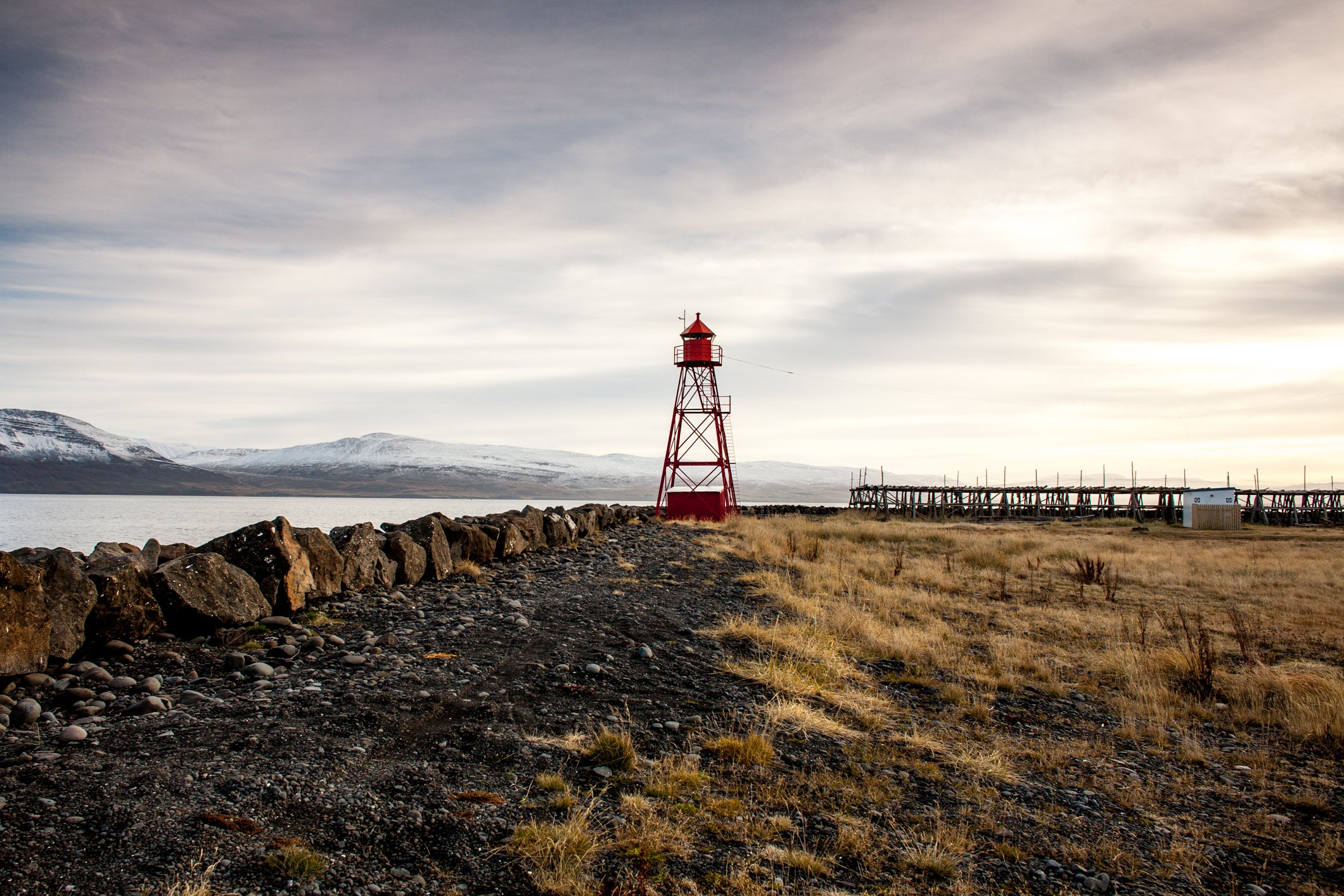 Siglufjordur lighthouse and surrounding landscape on a cloudy day.