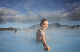 Eine Frau watet durch die Blaue Lagune.