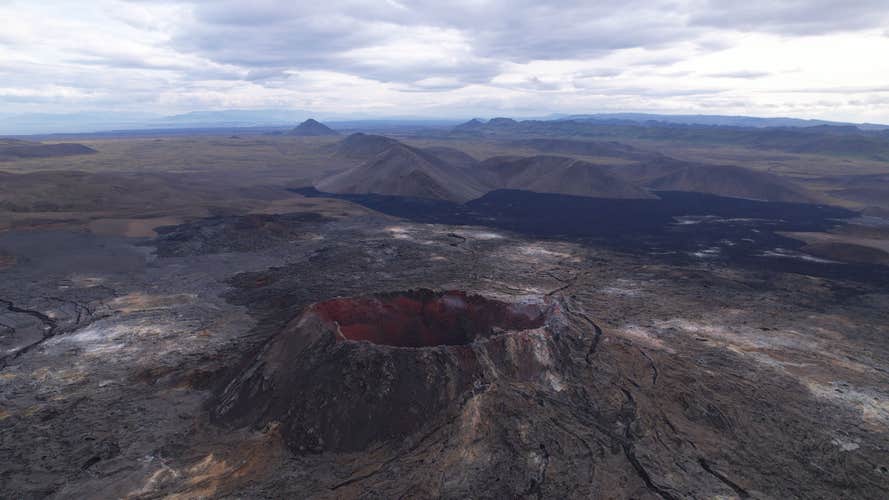 Volcanic eruption at Fagradalsfjall in Iceland's Reykjanes Peninsula, showcasing molten lava and smoke.