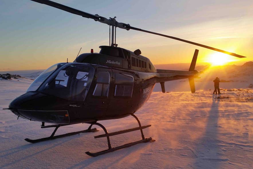 Schneelandung während eines Helikopter-Abenteuers bei Sonnenuntergang mit einem der besten Reiseveranstalter Islands.