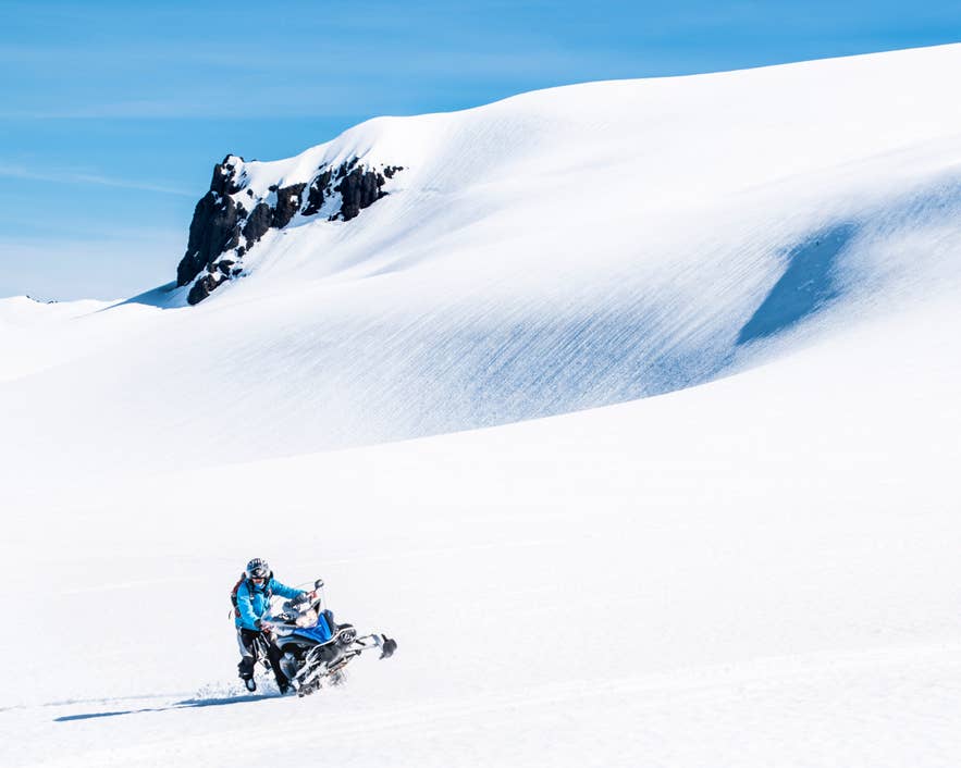 Schneemobilfahren auf einem Gletscher mit einem der Reiseveranstalter in Island, die aufregende Winterabenteuer anbieten.