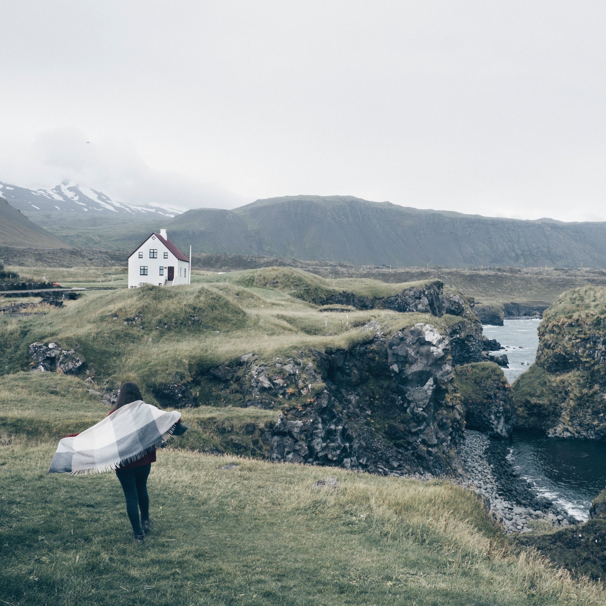 A traveler exploring the beautiful coastline of Arnarstapi on the Snaefellsnes Peninsula.