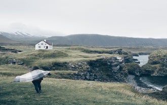 A traveler exploring the beautiful coastline of Arnarstapi on the Snaefellsnes Peninsula.