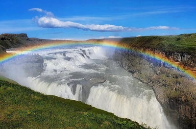 Chute d'eau de Gullfoss avec un arc-en-ciel jaillissant de sa brume épaisse.