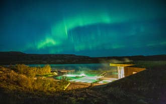 The northern lights glow above Vok Baths, creating a memorable setting for an evening geothermal bath in East Iceland.