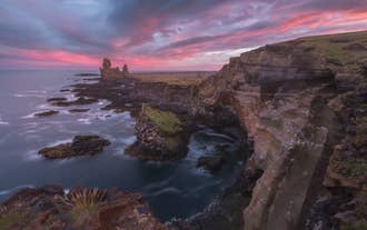 Londrangar Sea Cliffs at sunset on Iceland’s Snaefellsnes Peninsula with dramatic rock formations.
