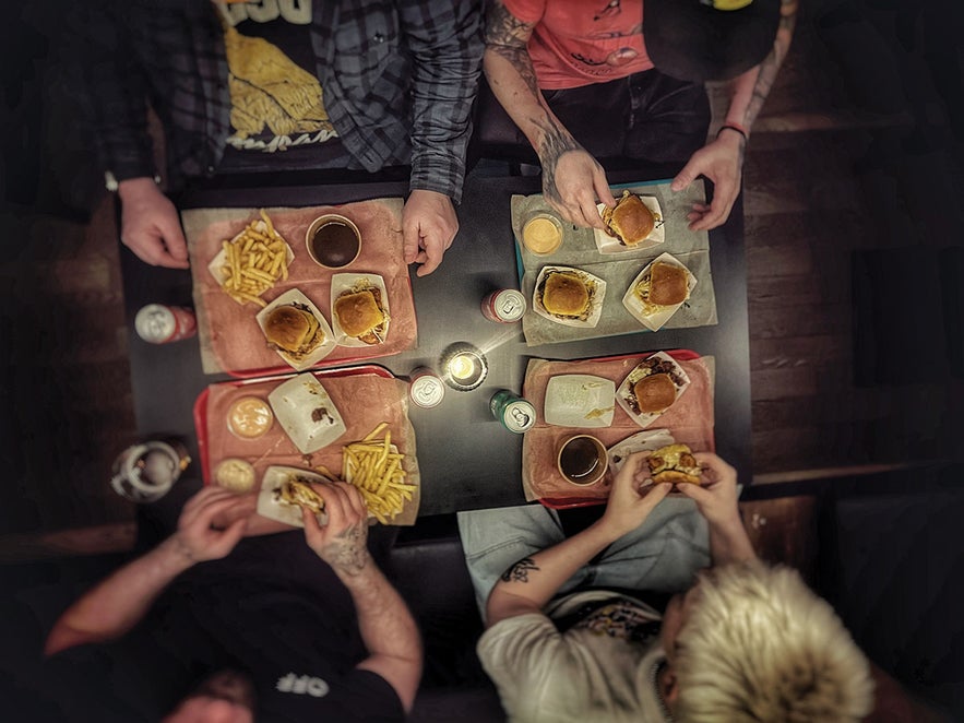 Friends enjoying slider-style smash burgers and fries at Brixton in Reykjavik, Iceland, a popular late-night burger spot. Friends enjoying slider-style smash burgers and fries at Brixton in Reykjavik, Iceland, a popular late-night burger spot.