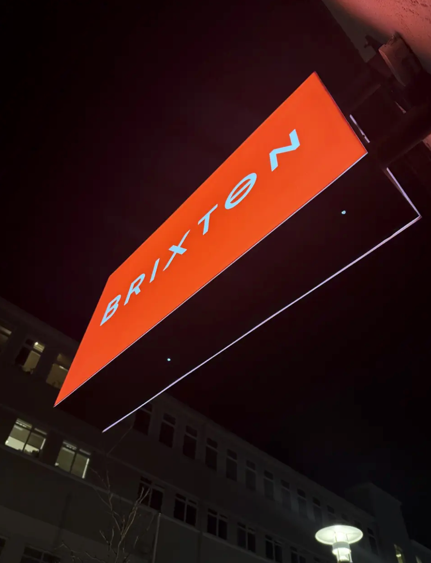 Brixton Reykjavik's illuminated red sign at night, marking the entrance to the popular burger bar in Iceland.