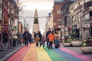 Una famiglia cammina lungo la strada di Skolavordustigur, a Reykjavik, dipinta di arcobaleno