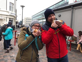 Two people eating a traditional Iceland hot dog.