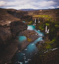 Landscape at Sigoldugljufur canyon with waterfalls and pristine blue-green water.