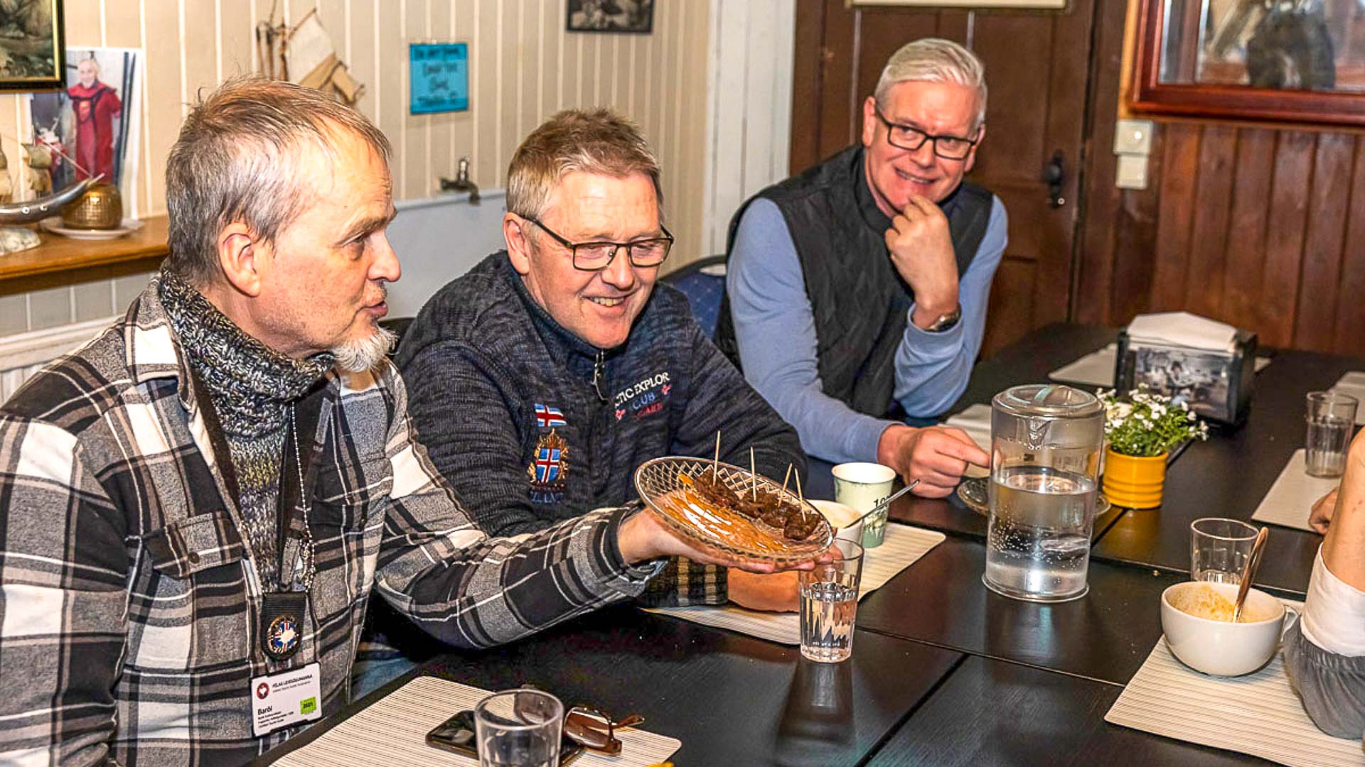 A guide shows a plate of samples to a group during a food tour of Reykjavik.