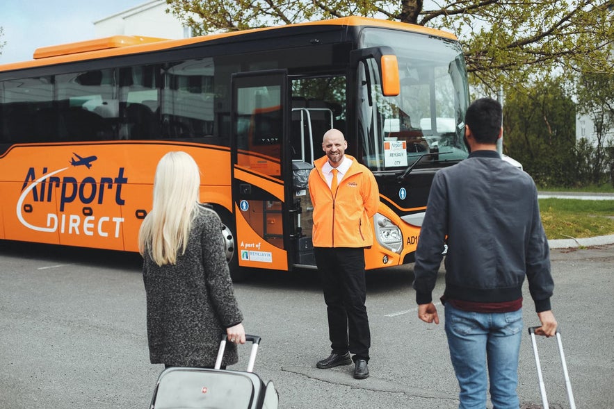 A friendly guide welcomes travelers to the bus transfer service in Iceland. 