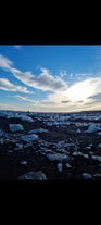 Ice scatters across a black sand beach in South Iceland.