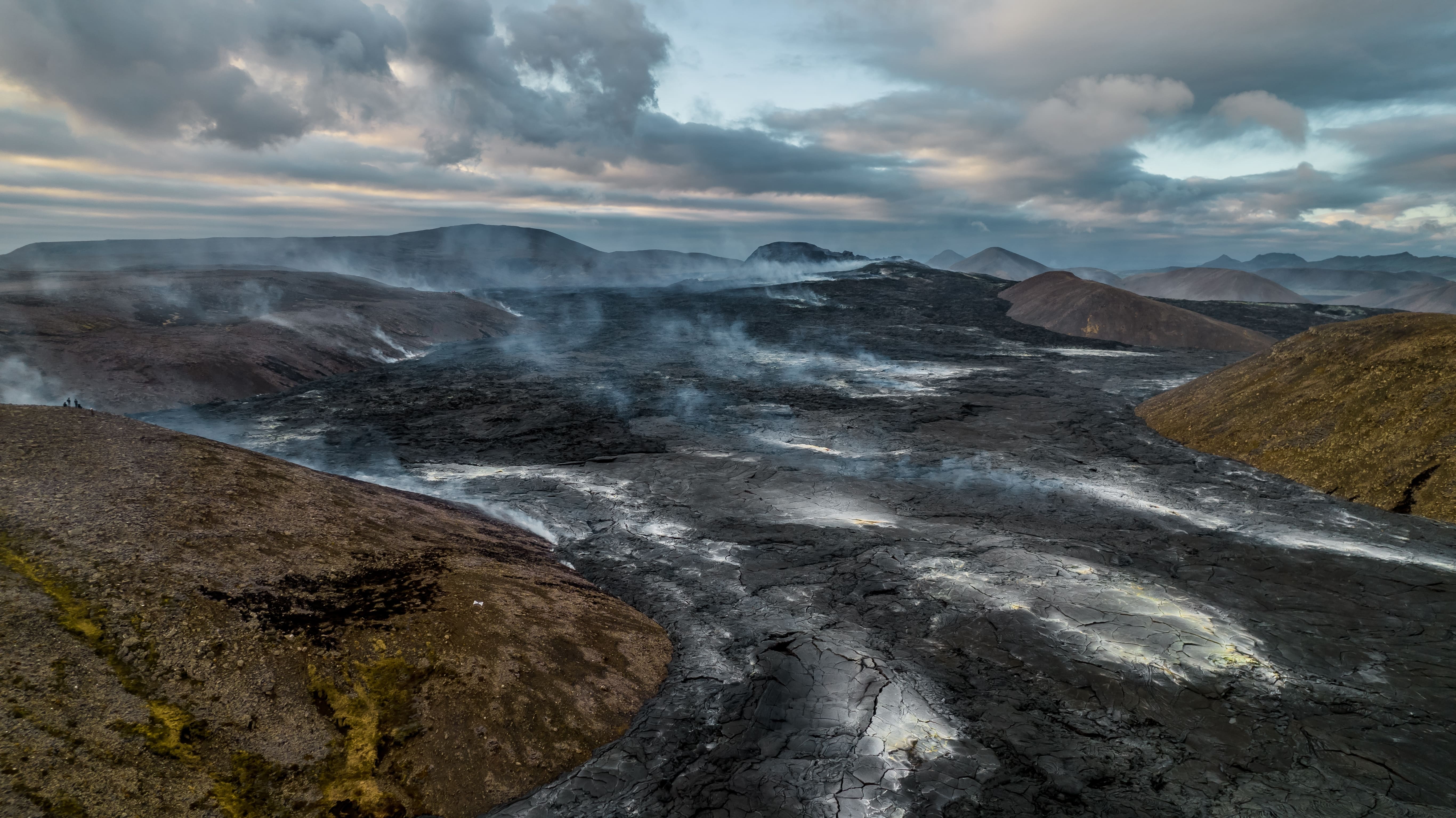 Vapor emergiendo de los oscuros campos de lava del Volcán Fagradalsfjall, un espectacular emplazamiento geotérmico de Islandia.