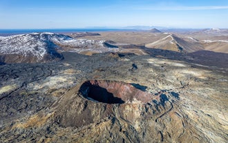 Luftfoto af et vulkankrater omgivet af lavamarker ved Fagradalsfjall-vulkanen på Islands Reykjanes-halvø.