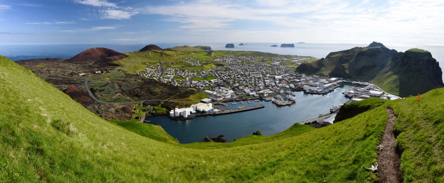 Panoramic view of Heimaey Island with harbor, town, lava fields, and sea cliffs in South Iceland&rsquo;s Westman Islands.