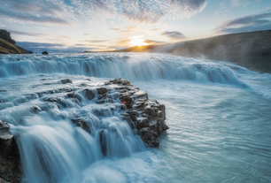 La cascata di Gullfoss brilla al tramonto nel sud dell'Islanda, una tappa imperdibile di un viaggio panoramico in auto lungo la costa meridionale.
