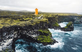 Le phare de Svortuloft se dresse sur une falaise accidentée de la Péninsule de Snaefellsnes, surplombant les vagues qui s'écrasent en contrebas.