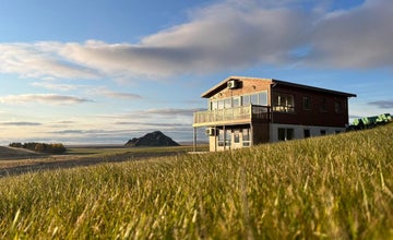 Uitzicht op Stora-Mork Guesthouse, omgeven door groen in de zomer in IJsland.
