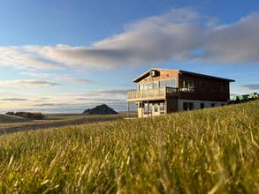 Widok na Stora-Mork Guesthouse otoczony zielenią podczas islandzkiego lata.