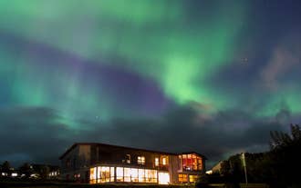 A beautiful display of aurora illuminates the winter skies above Stora-Mork Guesthouse in South Iceland.